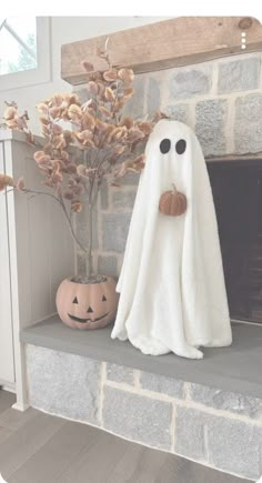 a fake ghost sitting on top of a mantle next to a potted plant and pumpkin