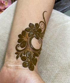 a henna tattoo design on the wrist and foot is very intricately decorated with flowers