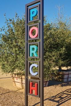 a large sign that is on the side of a road with trees in the background