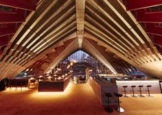 the interior of a restaurant with red walls and wooden beams on the ceiling, along with bar stools