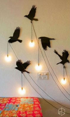 there are many birds flying in the air with lights on each side of the wall