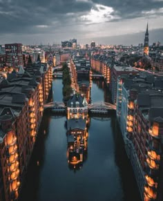 an aerial view of a city at night with lights on the buildings and boats in the water