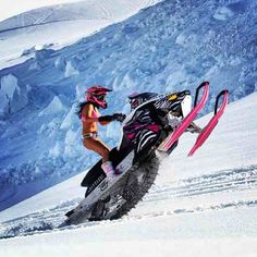 a woman riding on the back of a snowmobile