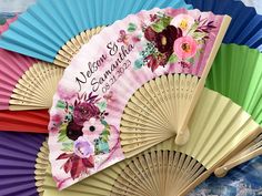 a colorful fan with flowers on it sitting in front of other colored fans that say welcome spring