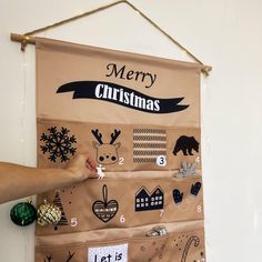 a person pointing at a bulletin board with christmas stickers on it's side