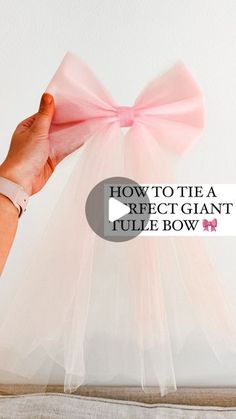 a person holding a pink bow on top of a white wall with the words how to tie a rectangle tulle bow