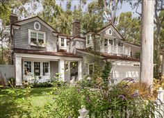 a white house surrounded by trees and bushes