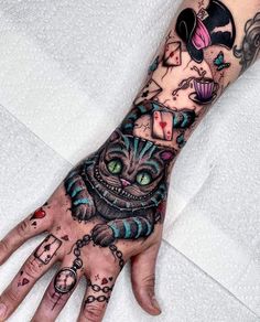 a person's hand with tattoos on it and an image of a cat in the middle