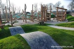 an outdoor play area with wooden structures and green grass