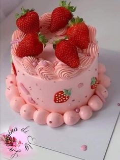 there is a pink cake with strawberries on top