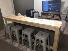 the bar is made out of wood and has stools around it, along with a flat screen tv