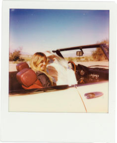 a woman sitting in the driver's seat of a convertible car