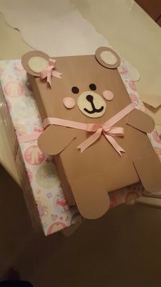 a brown paper bag with a teddy bear on it's back and pink ribbon around the neck