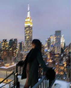 a woman standing on top of a building looking at the city