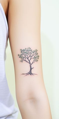 a woman's arm with a tree tattoo on it