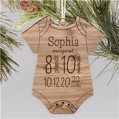 a wooden ornament hanging from a christmas tree with the birth announcement on it