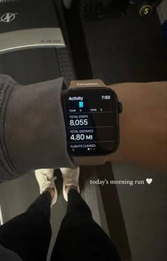 a person wearing a smart watch on their left hand and another person's leg in the background