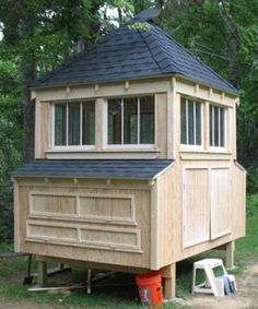 a small wooden structure sitting on top of a lush green field