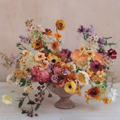 a vase filled with lots of different colored flowers