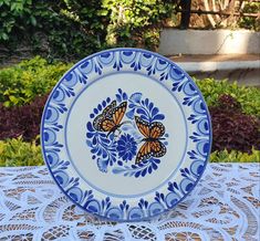 a blue and white plate with two butterflies on it