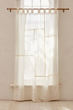 a white curtain hanging in front of a window