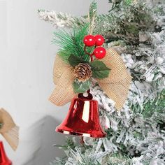 a christmas ornament hanging from the side of a tree with holly and berries on it