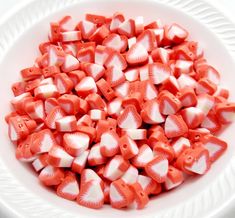 a white bowl filled with red and white candies