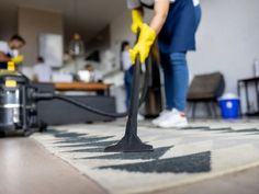 a person vacuuming the floor with a yellow mop and cleaning equipment in the background