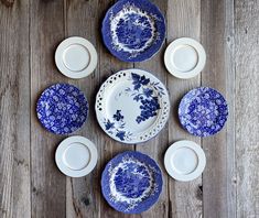 blue and white plates are arranged on a wooden table