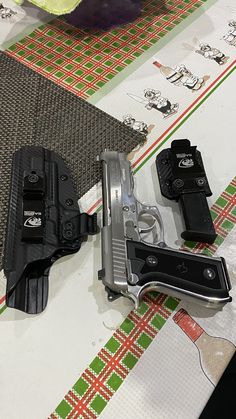 two handguns are sitting on a table next to some other items that have been placed around them