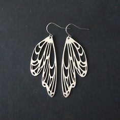 "Wing dangle earrings. Fabulous silver earrings for any of your outfits. Ear wires and charms are stainless steel. Light weight and comfortable to wear, 2.50\" x .75\". These Mystic Pieces delights will offer years of flight. A perfect gift for a Wedding, Anniversary, Birthday, Mother's Day, surprise for a special friend or delights for yourself. *Size* Length is 2.50 inches Width is .75 inches *FREE SHIPPING* I will get your lovely in the mail within 24 to 48 hours. Shipping is Monday through F Dragonfly Wing Earrings, Honey Bee Earrings, Dragonfly Insect, Wing Jewelry, Butterfly Wing Earrings, Dragonfly Jewelry, Angel Jewelry, Angel Wing Earrings, Insect Jewelry