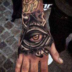 a man's hand with an all seeing eye tattoo on it