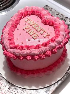 a pink heart shaped cake sitting on top of a counter