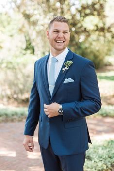 a man in a blue suit smiles at the camera