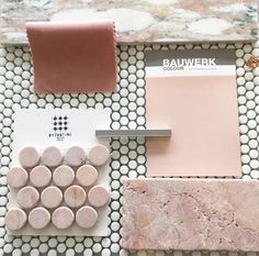 some pink and white items are on a marble table top with a tile pattern in the middle