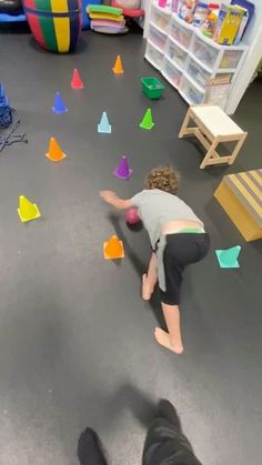 two children playing with toys in a playroom filled with plastic cones and colored shapes