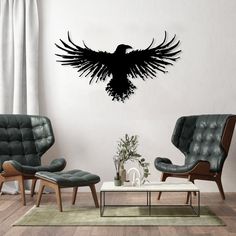 a living room filled with furniture and a large black bird wall decal on the wall