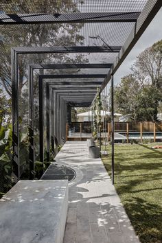 the walkway is lined with glass and metal poles, leading to an outdoor swimming pool