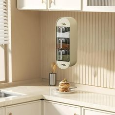 a kitchen with white cabinets and countertops has an over - the - door spice rack