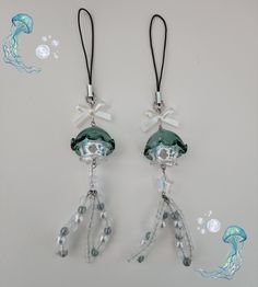 two clear glass beads hanging from black cord with white bows and pearls attached to them