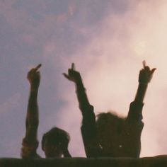 two people reaching up in the air with their hands