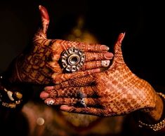 two hands with henna and ring on their fingers