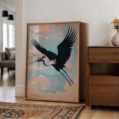 a large bird with a long beak flying through the sky in front of a painting