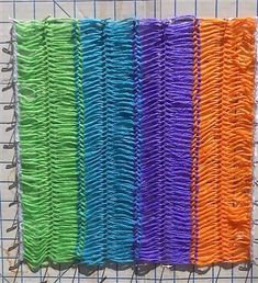 several different colors of thread on a piece of cloth