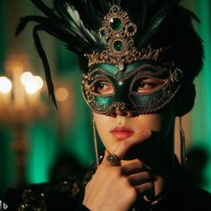 a woman wearing a mask with feathers on her head and green eyeshade, in front of a chandelier