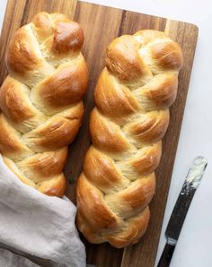 two loaves of bread sitting on top of a cutting board