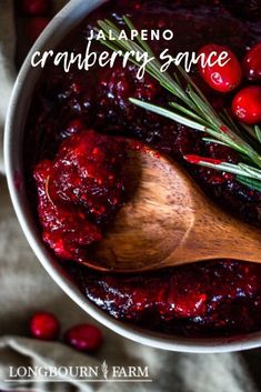 cranberry sauce in a white bowl with a wooden spoon next to it and the words, jalapeno cranberry sauce