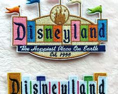 the disneyland sign has been embroidered on to it's back and is in different colors