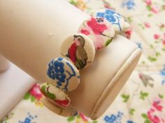 a close up of a person's arm wearing bracelets with flowers on them