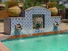 an outdoor fountain with blue and white tiles